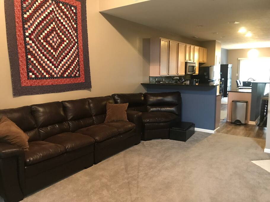 Common Area: Living room leading into the kitchen. The sofa is really comfy! There is a wall-mounted tv across from the sofa.