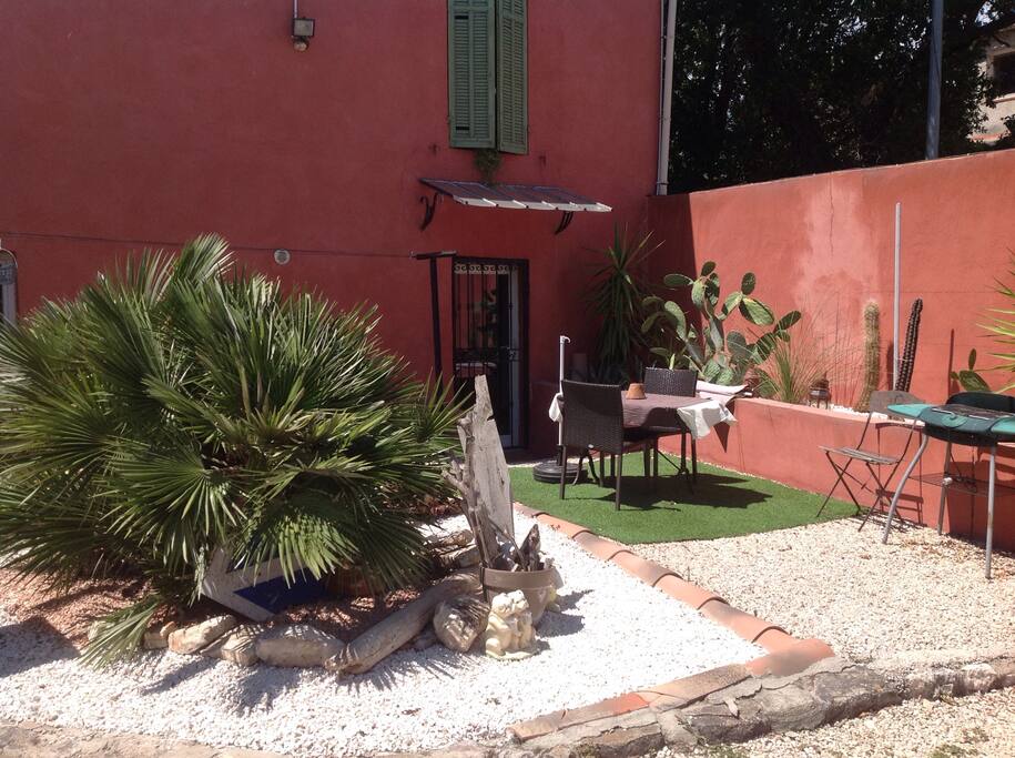 Terrasse privative avec salon de jardin, barbecue électrique et parasol.