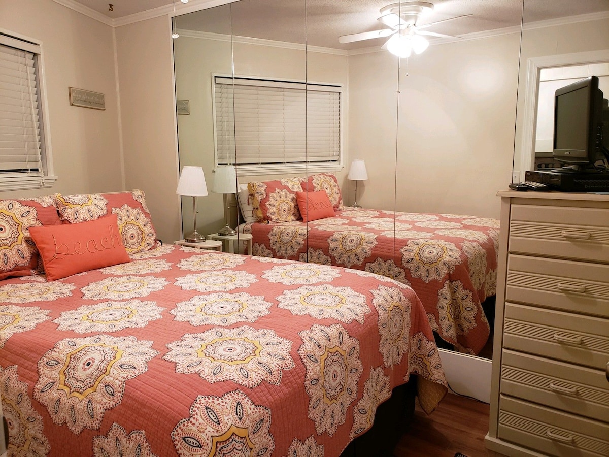 Manželská posteľ a inteligentná televízia v hlavnej spálni s množstvom zrkadiel na prípravu