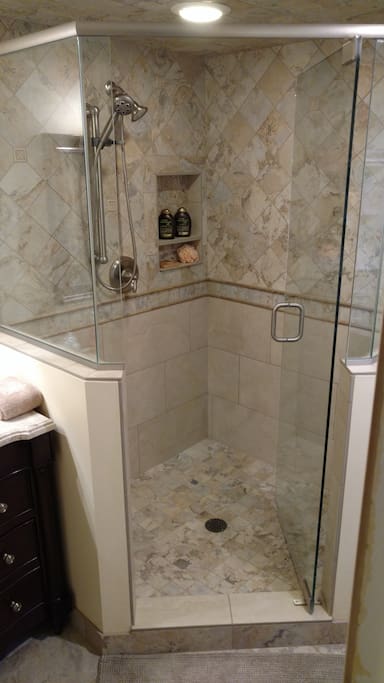 This roomy walk-in shower has a fold-down seat for those who need it.