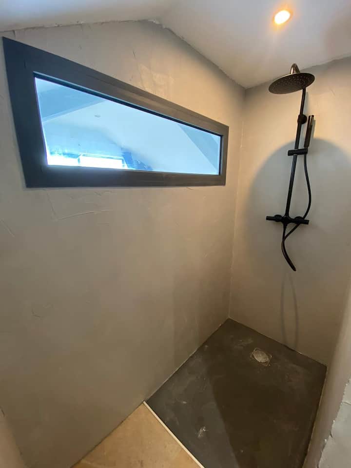 The upstairs master suite with a zoom on its private bathroom from where you can admire the ocean while showering 