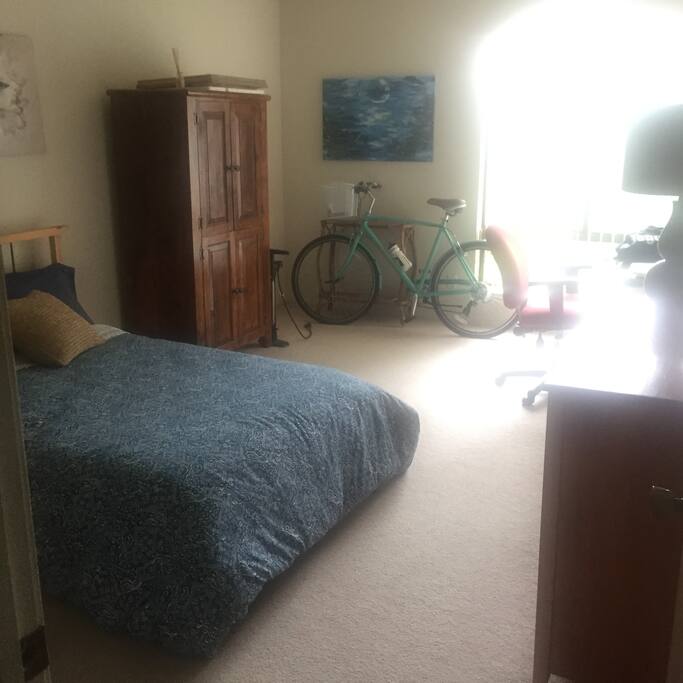 Very Large, Bright bedroom with large window overlooking trees and further away pool area
