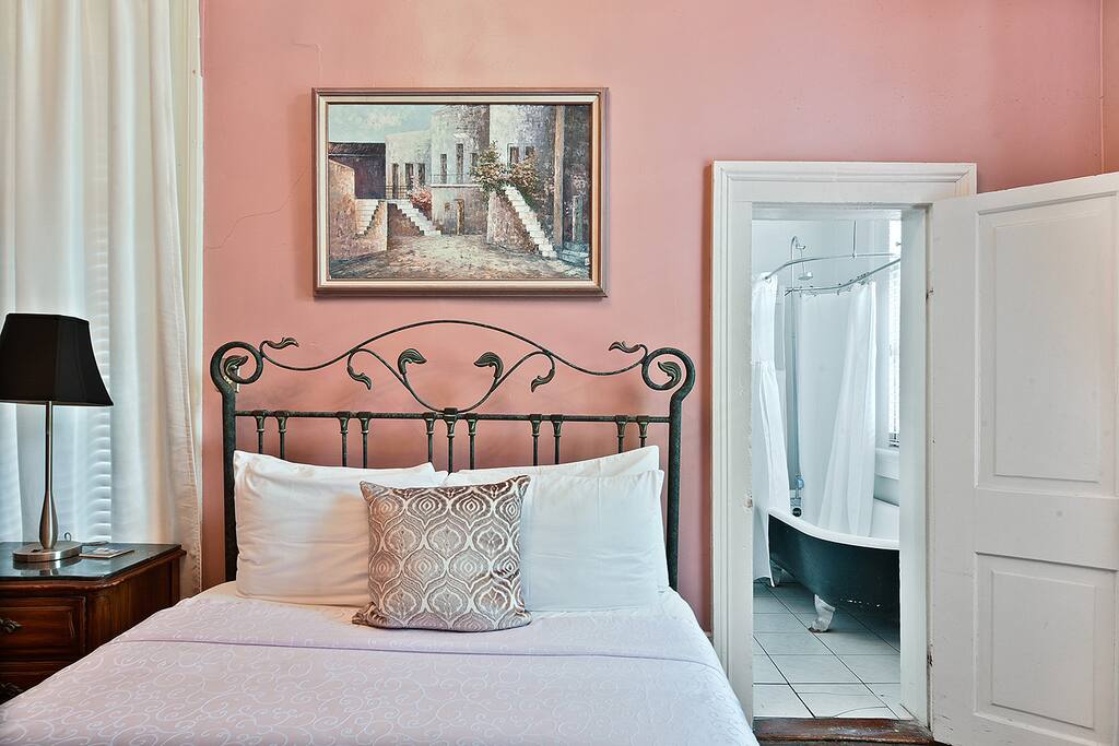 The attached bathroom (right side of bed) has an antique bear claw tub, very popular in historic homes