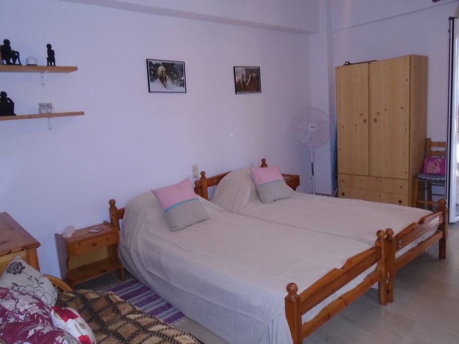 Beds and cupboard with fan next to it.