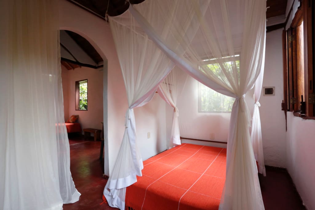 O primeiro cômodo tem duas janelas, cama de casal, um gaveteiro e prateleiras