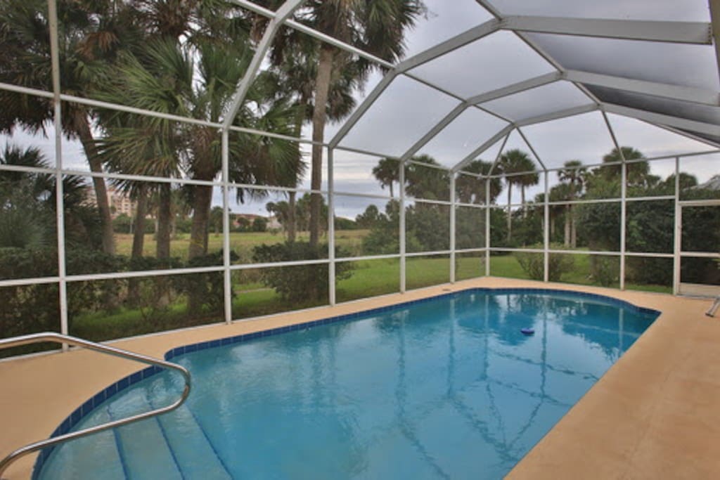 Private, screened in pool with view of the golf course and pond.