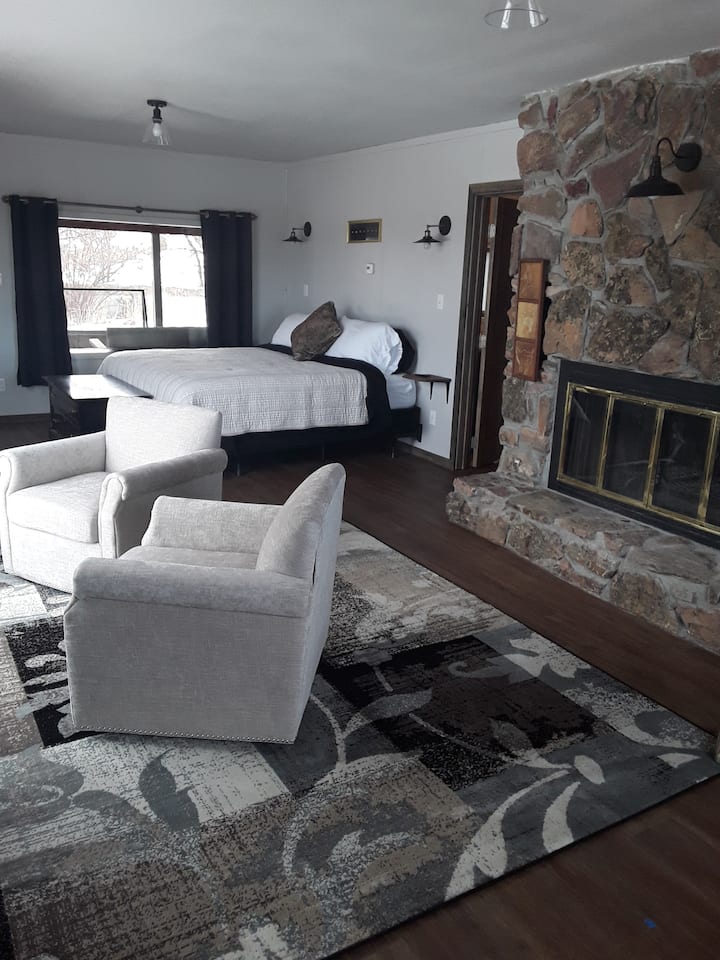 Spacious master bedroom with sitting area and fire place.