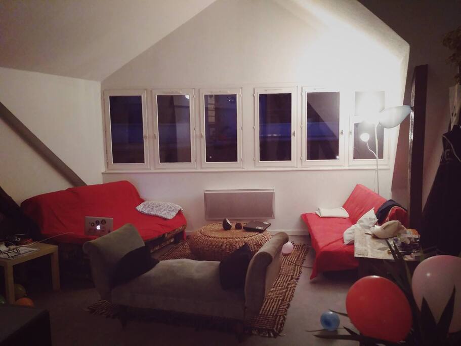Grand salon cosy et très lumineux en journée, très haut de plafond