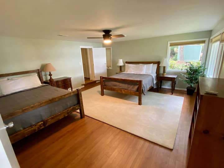 Dos camas tamaño queen en el DORMITORIO del sótano de estilo PRINCIPAL con baño adjunto