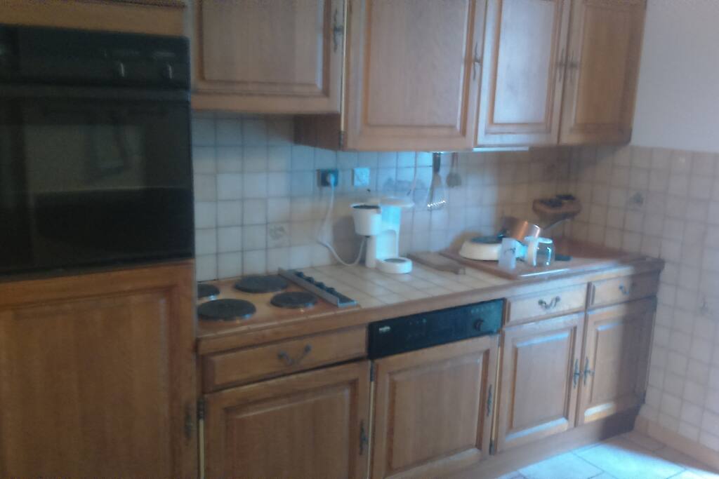 cuisine avec four, plaque, frigo et tout le nécessaire pour cuisiner.