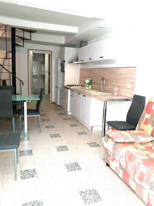 cuisine et séjour. Au fond, salle d'eau, toilettes et buanderie