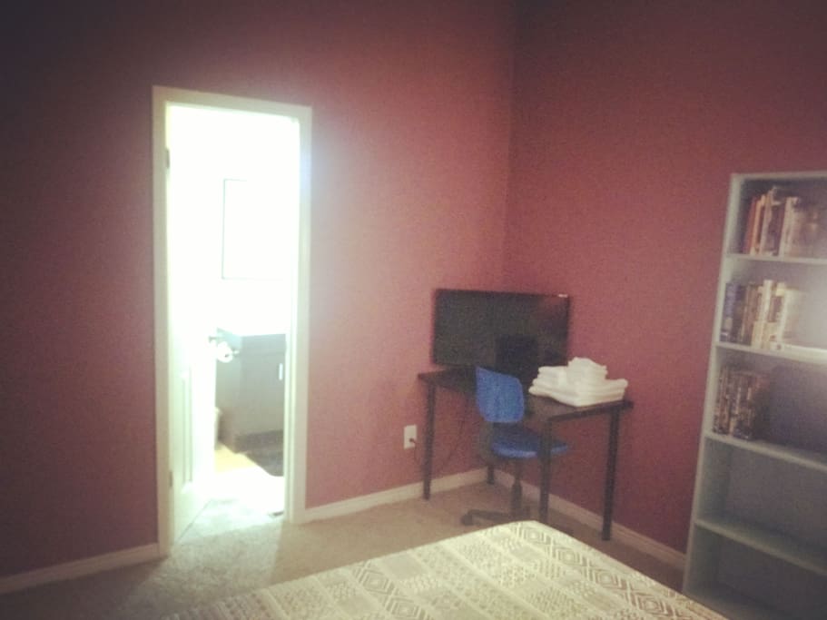 view of TV and bathroom entrance