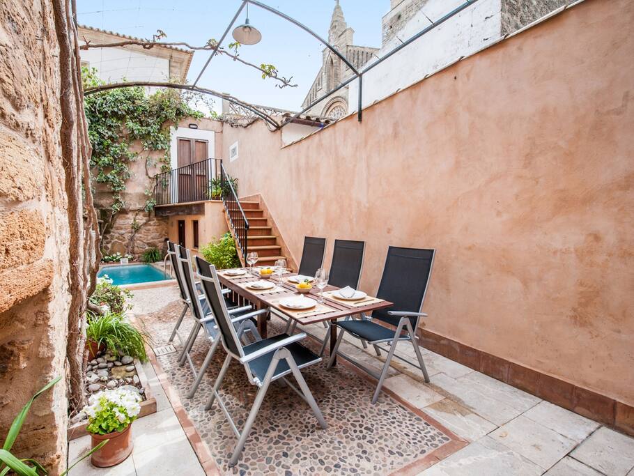 Comedor en el patio de la casa con vistas a la piscina.