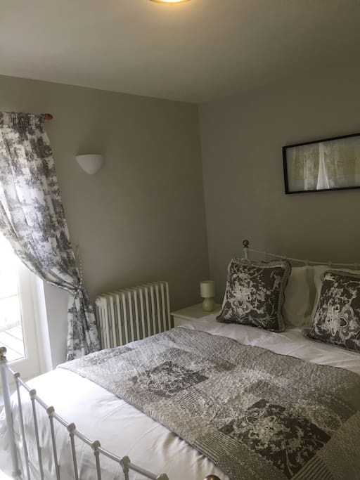 King bedroom with patio doors to balcony with garden view