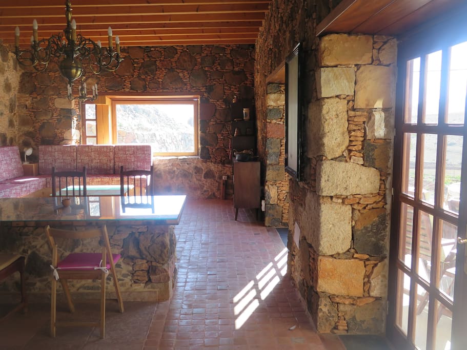 Detalle de piedras esquineras hechas en la finca y ventanal al fondo con bonitas vistas