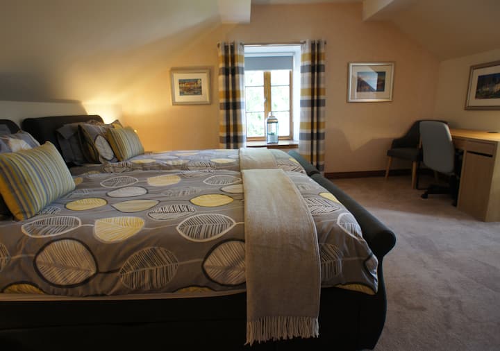 חדר שינה זוגי מואר ומרווח עם חדר רחצה משפחתי סמוך וחלל עבודה, מגבות ומצעים איכותיים