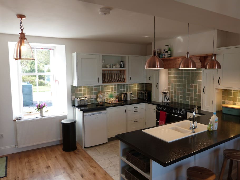 Bespoke fully equipped kitchen with views to forest and Fairy Hill.
