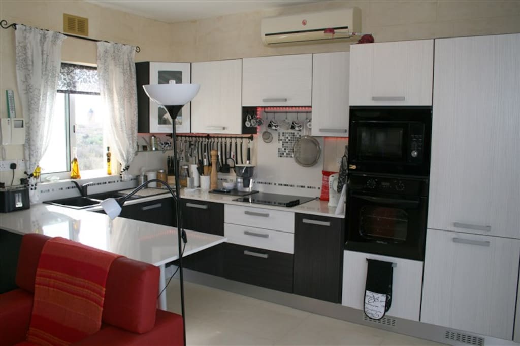 Kitchen fully equipped with electric hob, oven, microwave and fridge freezer