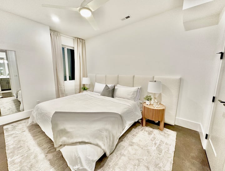 First floor bedroom with King bed, luxury linens, full size mirror, and double-door closet to hold all of your shopping finds. 