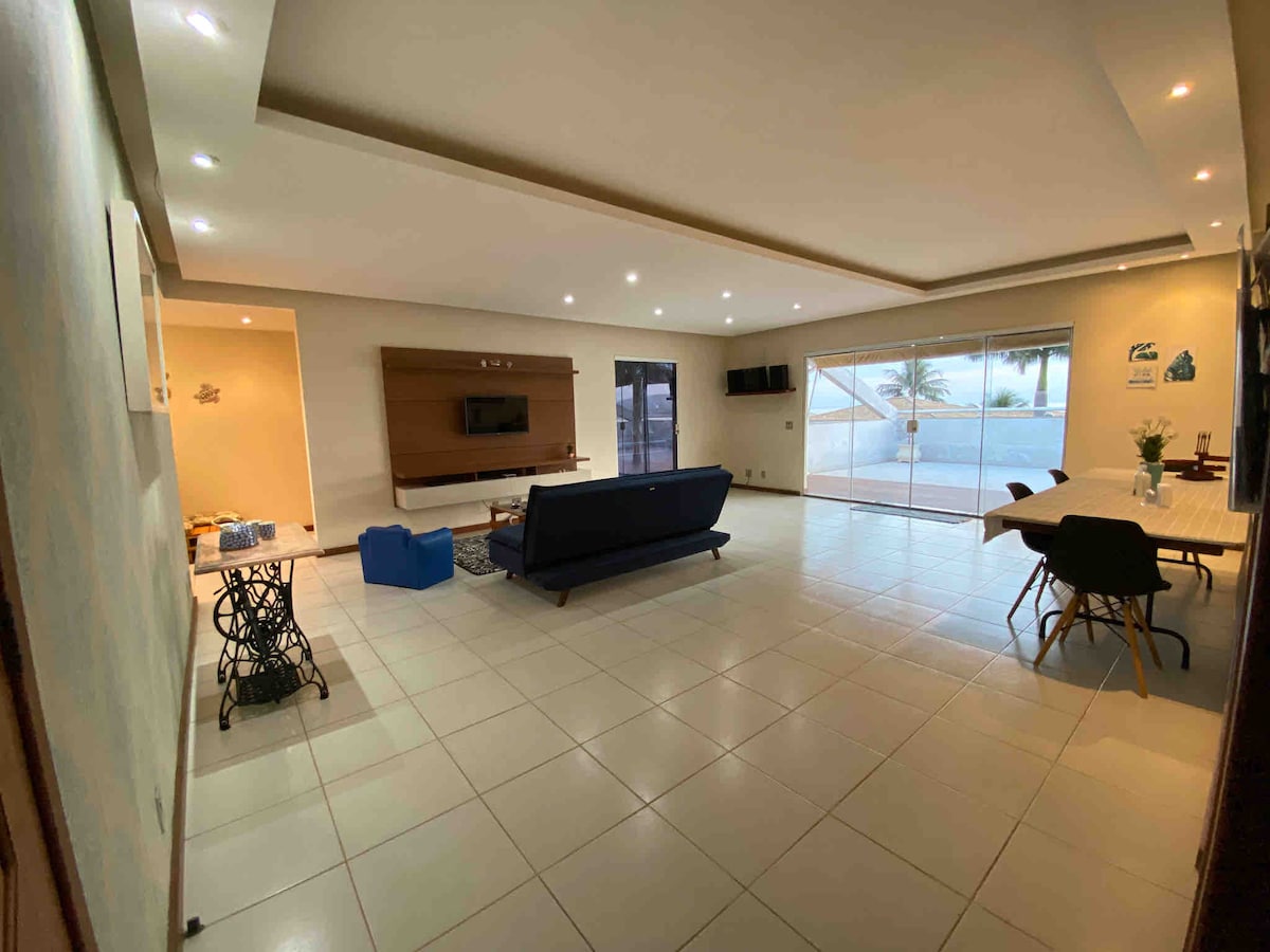 Veľká obývacia izba vybavená televízorom so všetkými kanálmi a streamovacími službami a rozkladacou pohovkou, vlastným balkónom na čítanie, jedálenským stolom pre 10 osôb a kobercom na hranie s malými deťmi.