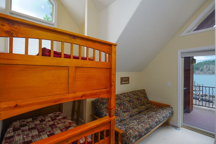 Guest room with access to balcony shared with other guest bedroom.  Bedroom has twin bunk beds and full sleeper.
