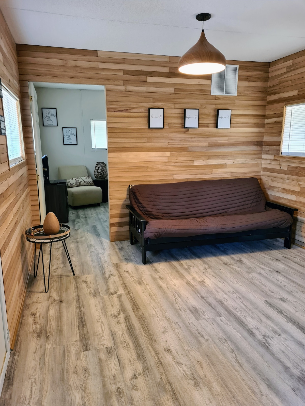 غرفة معيشة مع جدران من السيبريس وسرير أريكة.