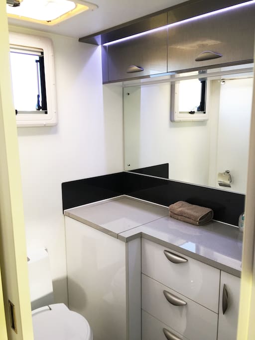A great little bathroom with a washing machine to the left of the drawers