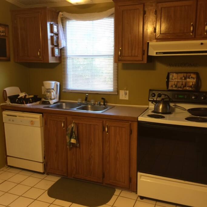 Large kitchen area with breakfast bar and small dining table .
