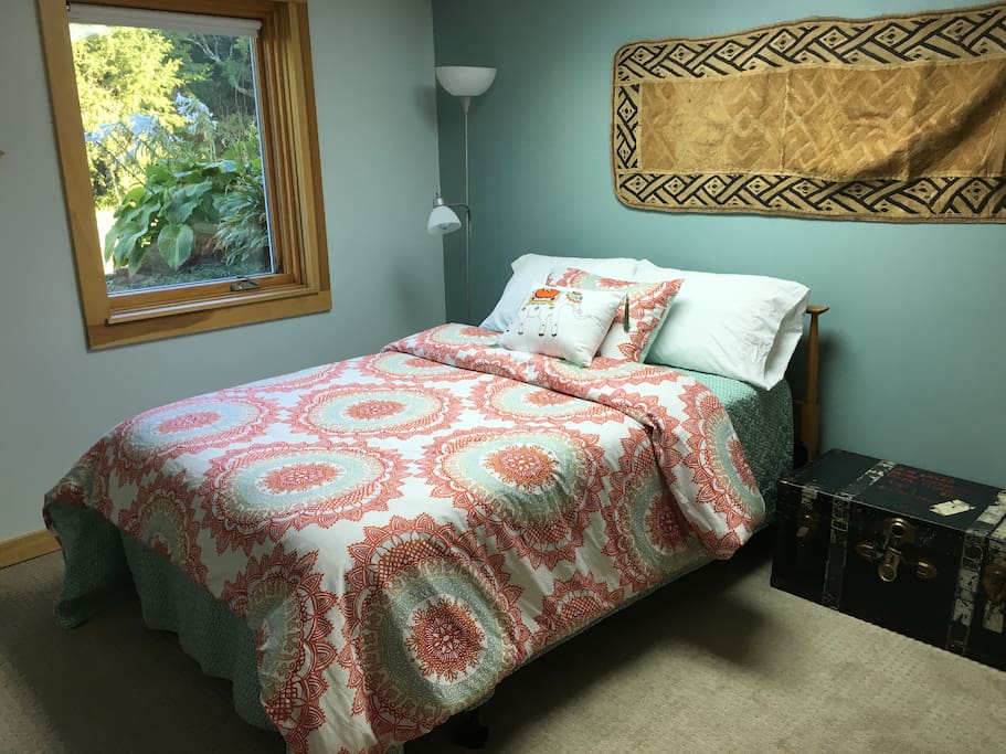 Full size bed. Window looks out on forest.