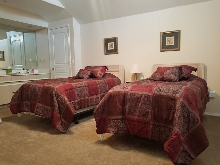 Chambre loft avec lits jumeaux, lavabos doubles et douche à baignoire combinés.