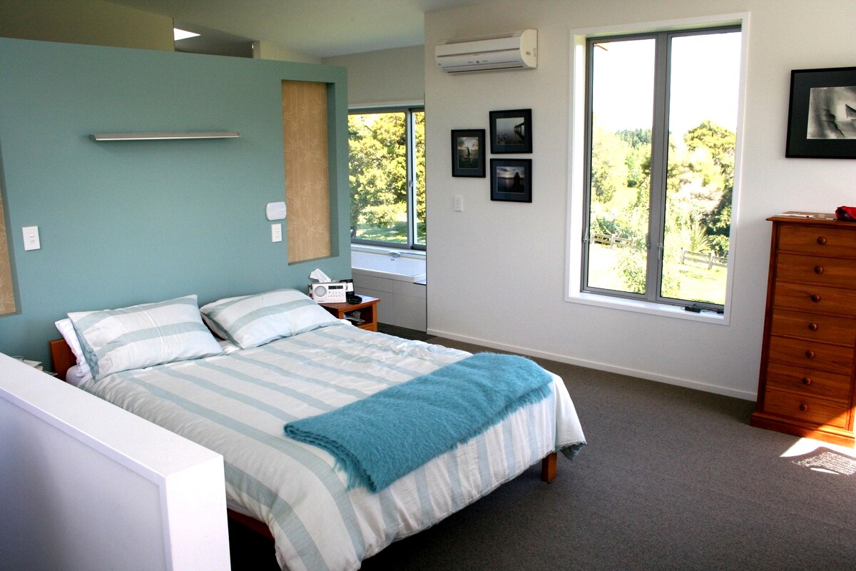 Chumba cha kulala cha ghorofani chenye mwonekano wa kuvutia ikiwa ni pamoja na anga nzuri ya usiku wa Wairarapa. Bafu kubwa lililoambatanishwa na beseni la kuogea na bafu la wazi.