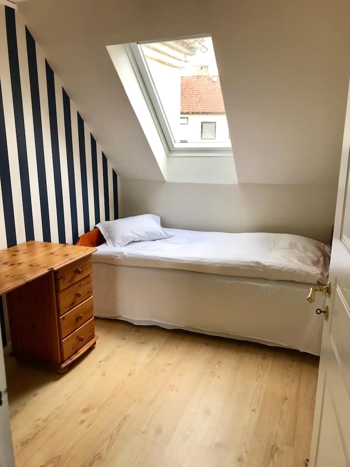 Slaapkamer met een eenpersoonsbed en ruimte voor extra matras