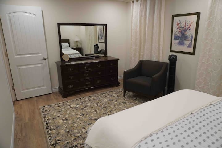 The large bedroom has a full bureau for storage, a hooked wool rug to warm your feet, and a slipper chair. There is a tower fan in the room, split system heat pump for A/C, and an air purifier.