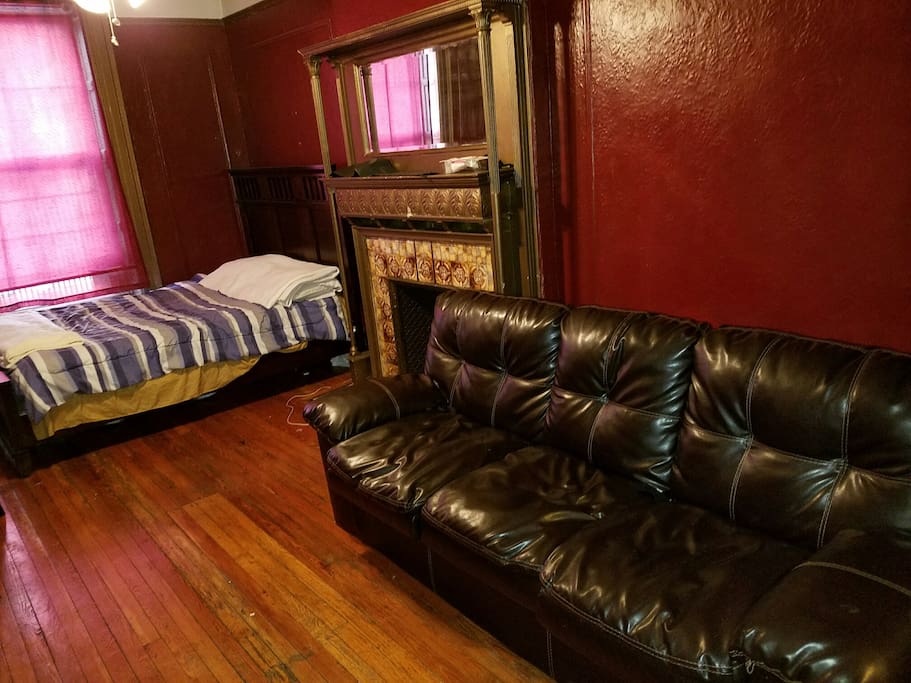 Large living room has queen size bed, couch, table and chairs, decorator fireplace