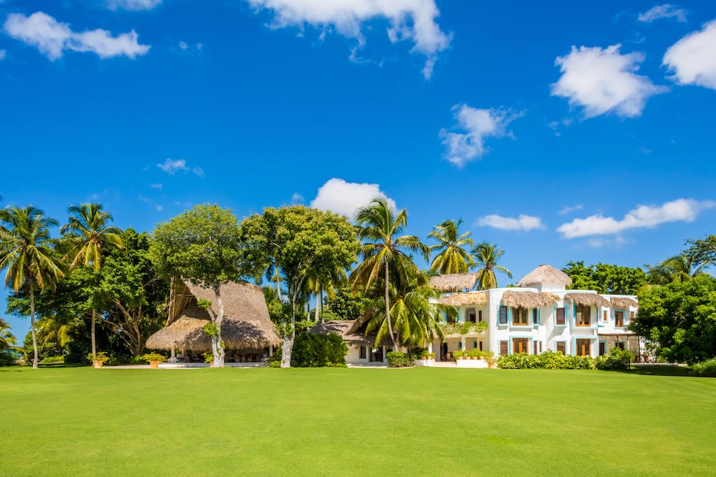 The main house looks across an expansive lawn and out to the sea