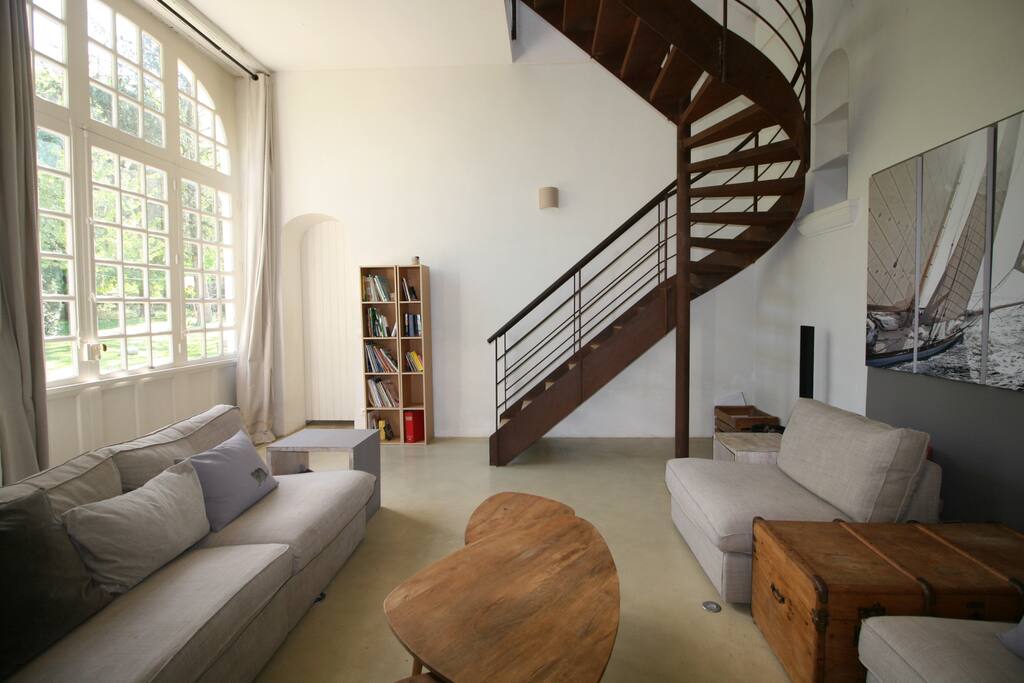 Le salon avec ses grandes baies, sa hauteur sous plafond de 4m ! et son escalier en acier.