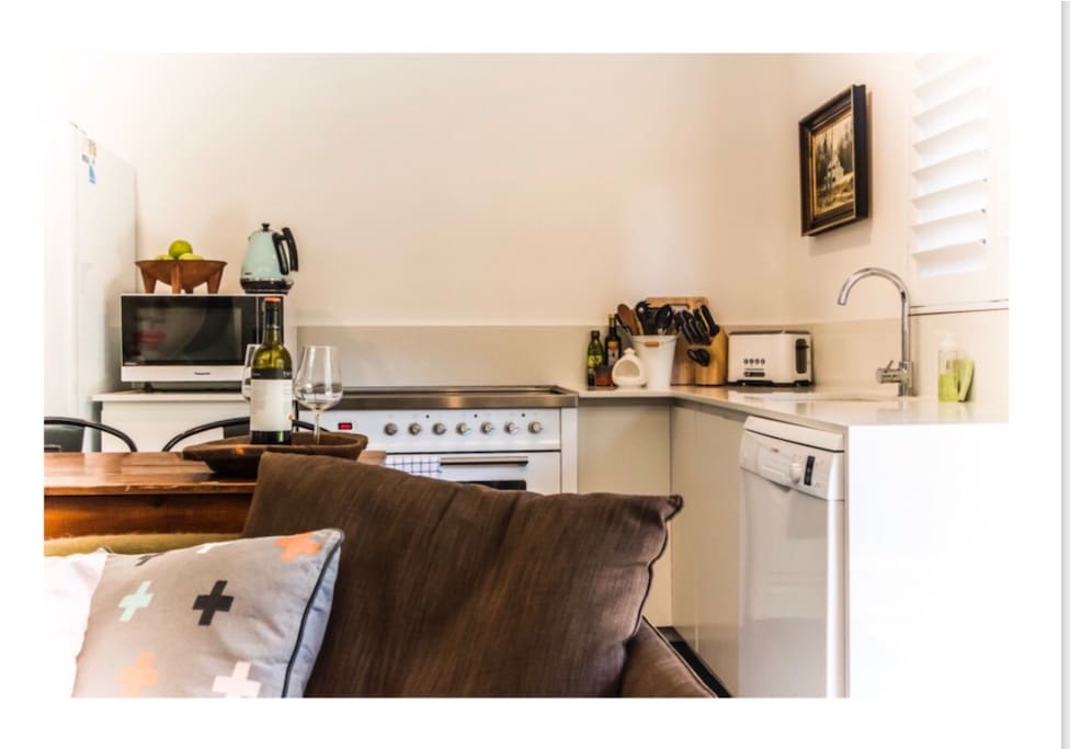 Well stocked kitchen with 90cm Ilve stove and two seat dining area