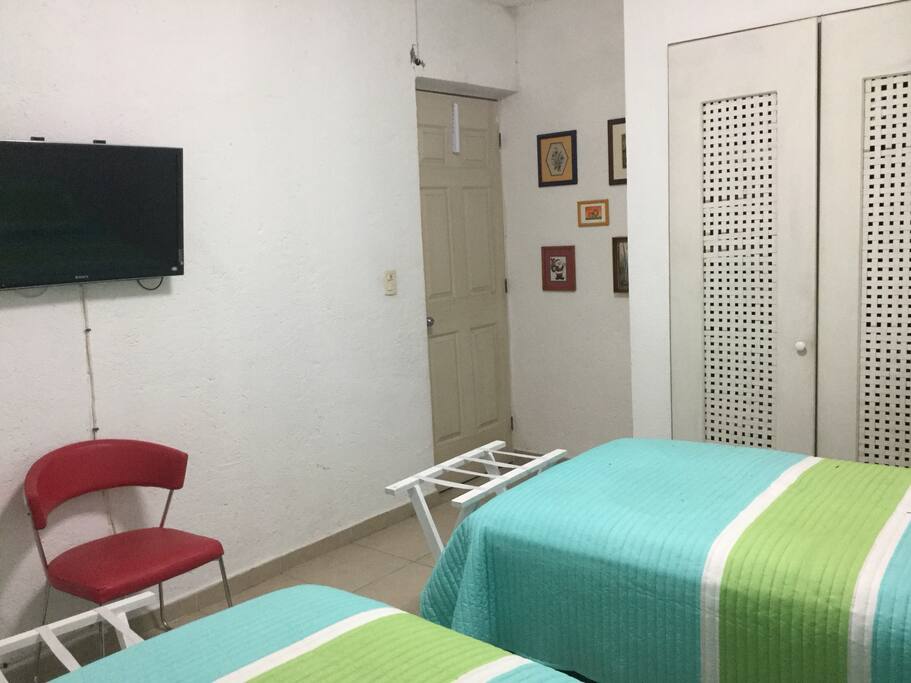 la pared de enfrente a las camas, con la T.V.