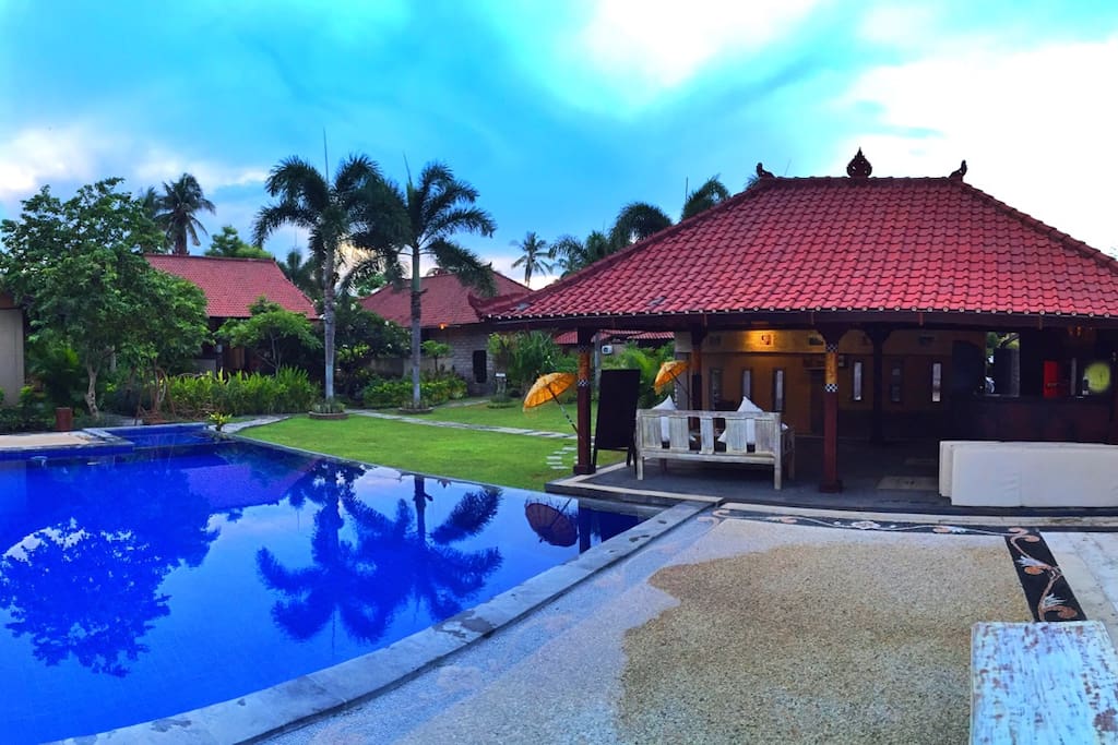 Out door pool surrounding with green garden and confy to spend your holidays in Bali