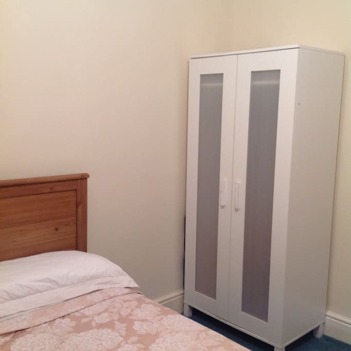 Wardrobe space with hangers and extra bedding provided.