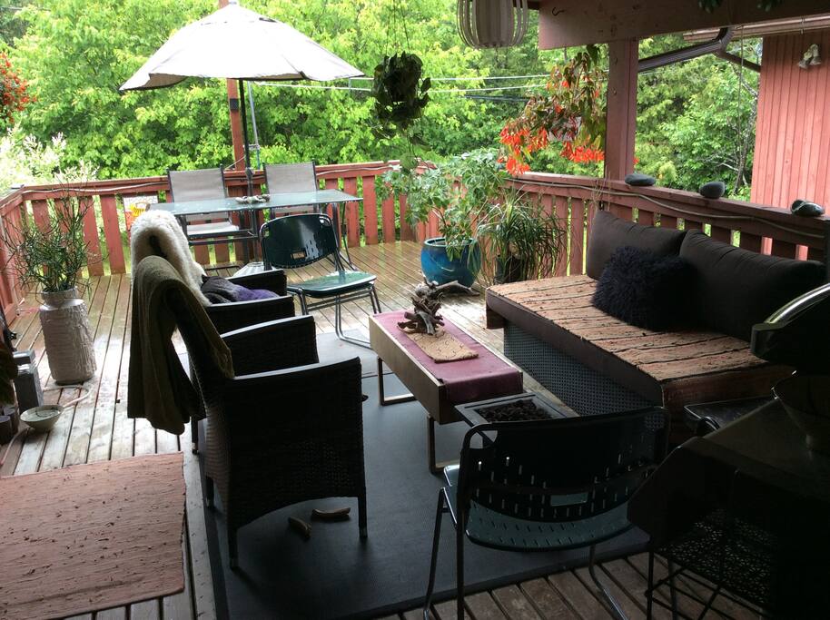 Gorgeous covered outdoor living room patio with bbq.
Surrounded by greenery.