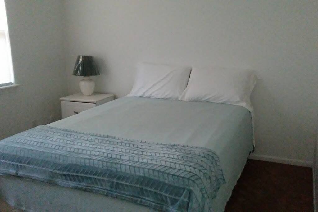 Quiet Restful well-lit Room w/ Queen size bed, dresser, side table, & windows face west.