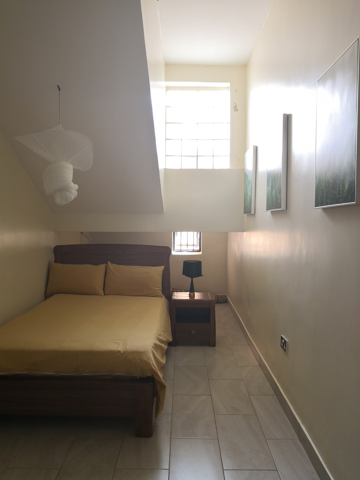 Spálňa 4 s malou manželskou posteľou, sieťkou proti komárom, odkladacím stolom a lampou. 