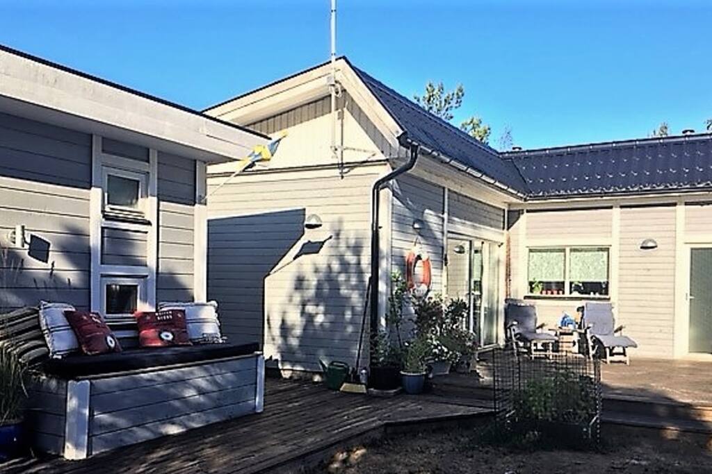 Stor terass med flera platser för avkoppling i sol, skugga samt under tak