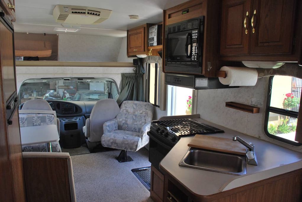 Full kitchen and living area. Above the driving cab is a king sized bedroom area.