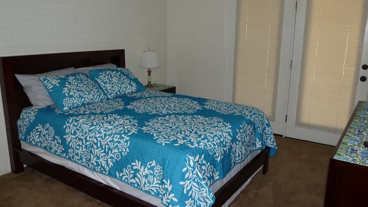 Master bedroom with large screen TV and access to patio.