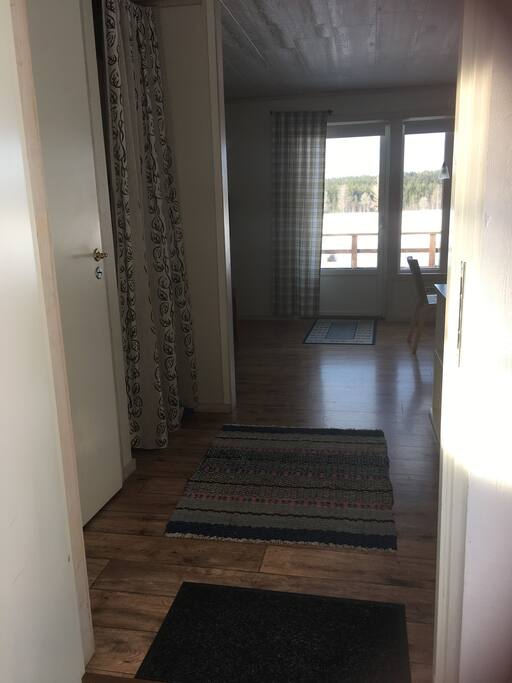 Välkommen in! Rakt fram syns utgången till altanen med utsikt över skogar och fält.