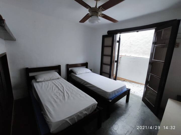 Quarto 4 (acomoda 2 pessoas) – 2 camas de solteiro, acesso para varanda conjugada com o Quarto 5. Ventilador de teto e ar-condicionado.