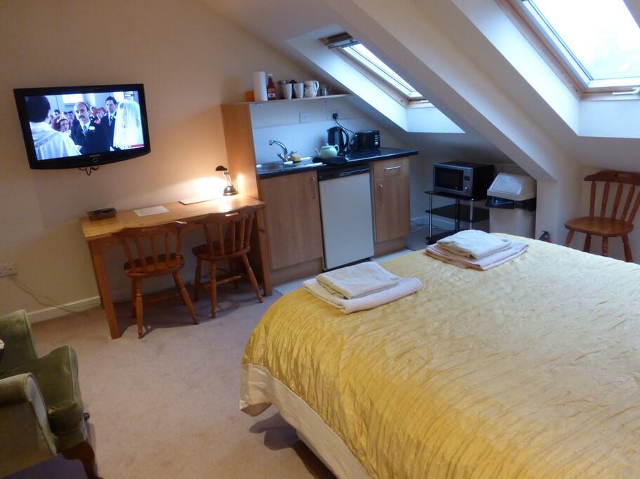 Wall mounted tv with freeview channels. Dining/study table and kitchenette with full size larder fridge, sink, kettle, toaster and combined microwave and grill.
