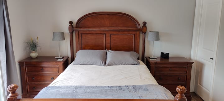 Main Floor Bedroom  - It has one queen bed with two pillows, two side tables, two nightside lamps, art, decor, an alarm clock, a large chest of drawers to store your clothes and sliding glass doors to the balcony overlooking the beautiful lake. 
